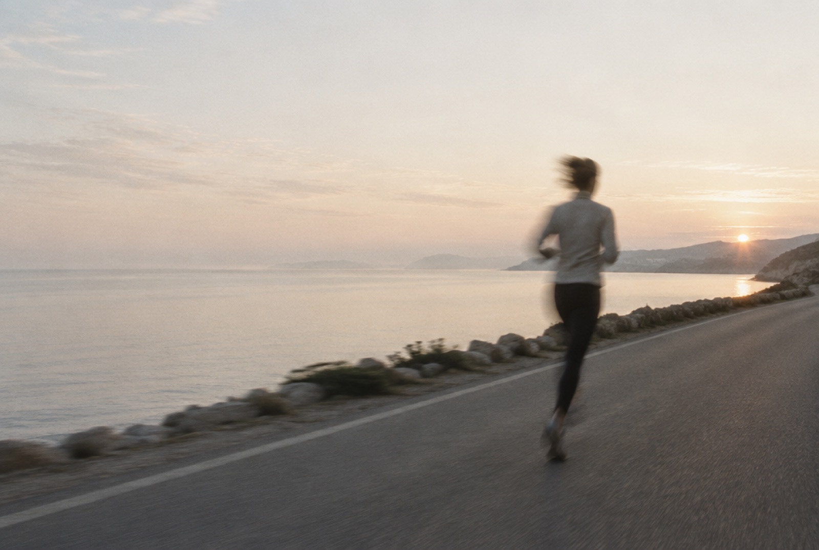 A runner on a coast road at first light